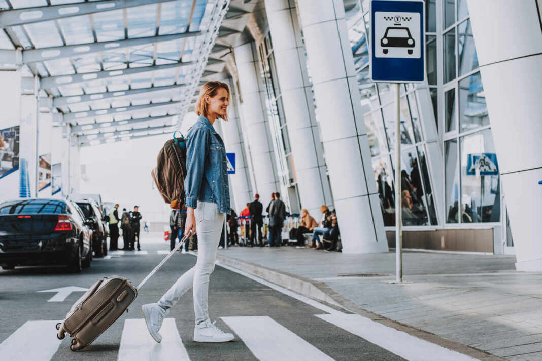 Mujer viajera con maleta en pleno recorrido, ejemplo de los trabajos que pagan por viajar por el mundo