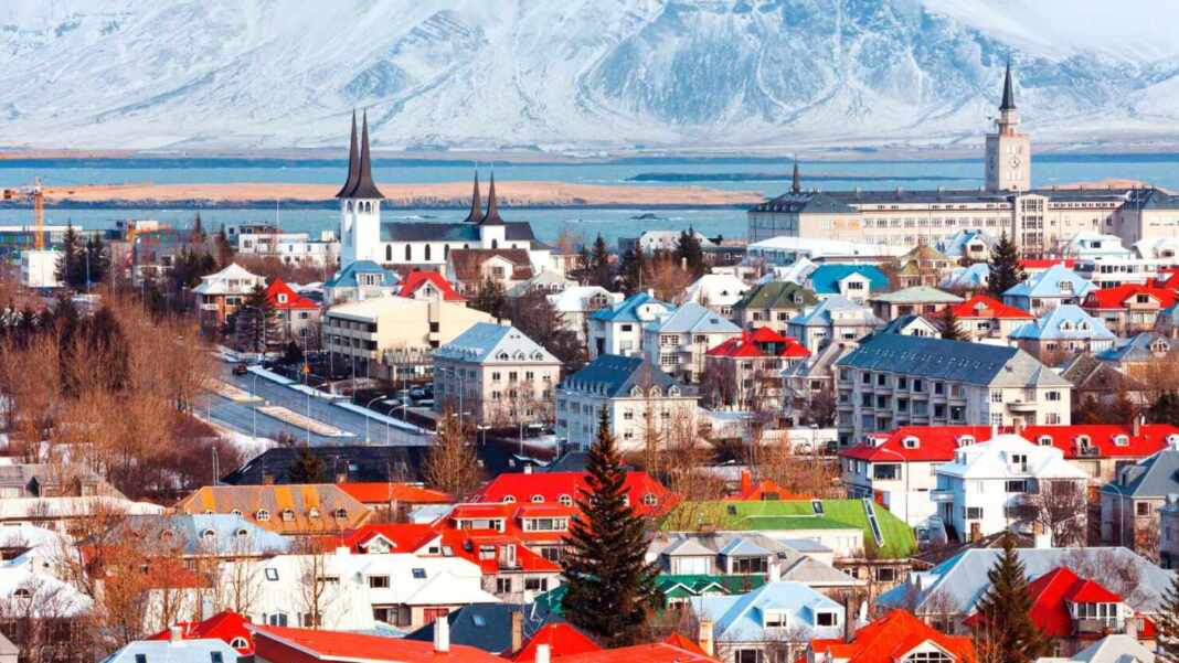 Casas de colores de Reikiavik con montañas nevadas al fondo, ciudad de la universidad que ofrece el curso de islandés gratis
