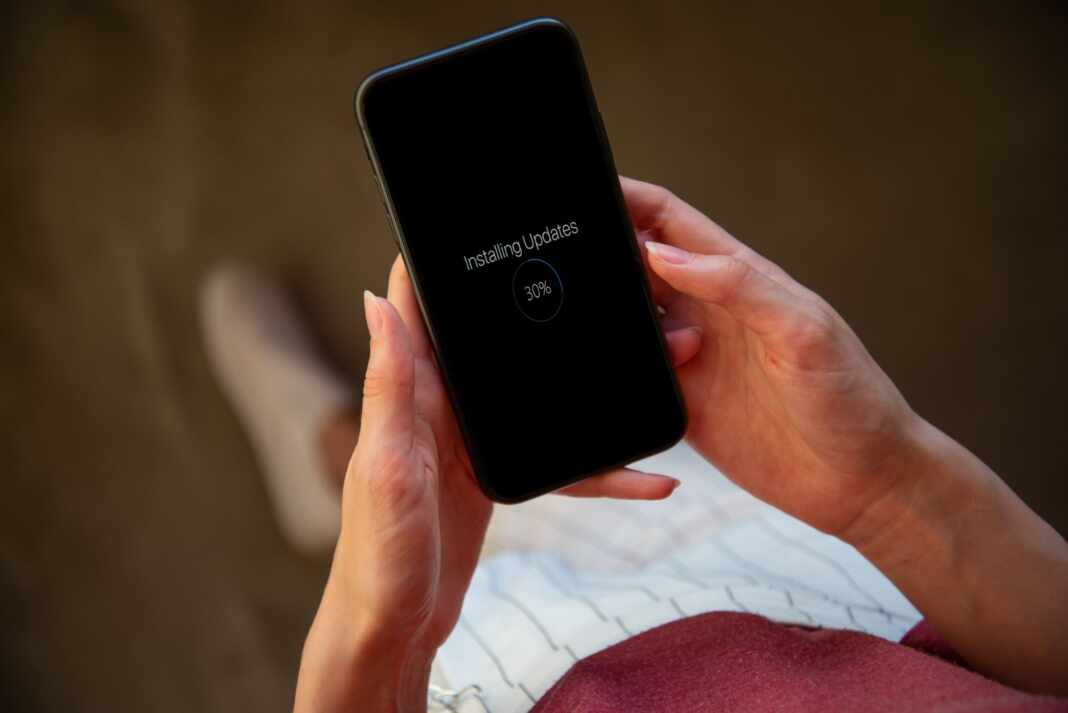 Mujer sostiene un iPhone mientras se instala una actualización del sistema