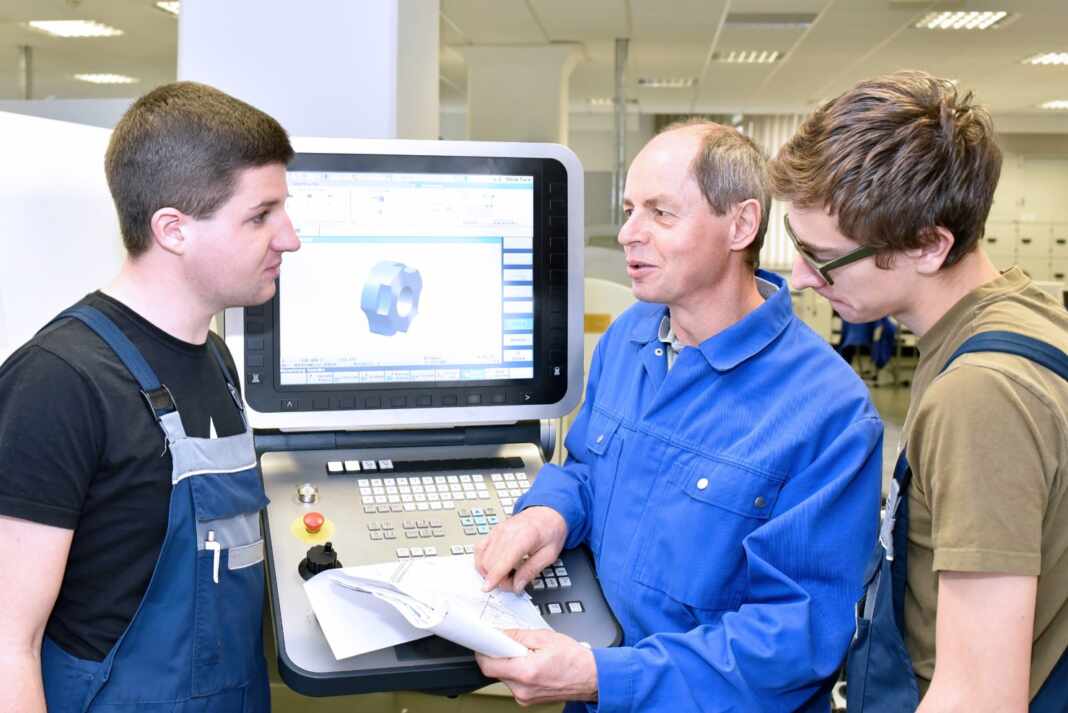 Grupo de jóvenes en formación técnica con su instructor en un taller