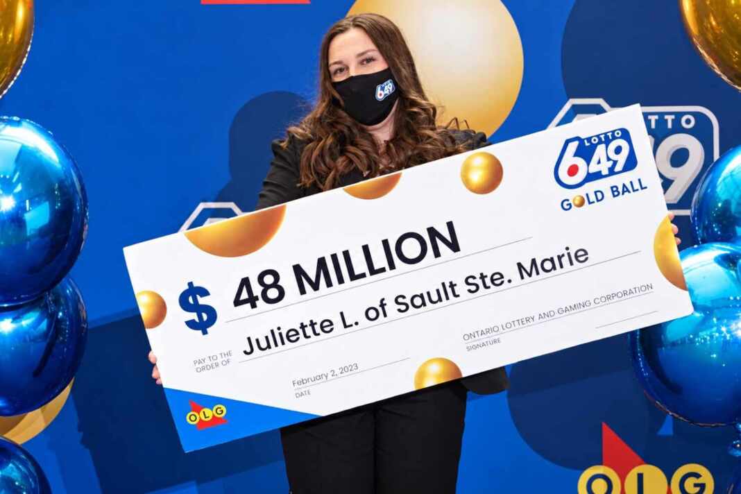 Juliette Lamour sostiene el cheque de 48 millones de dólares canadienses