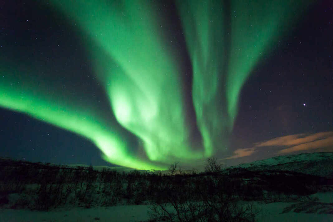 Aurora boreal sobre un paisaje nevado en Laponia