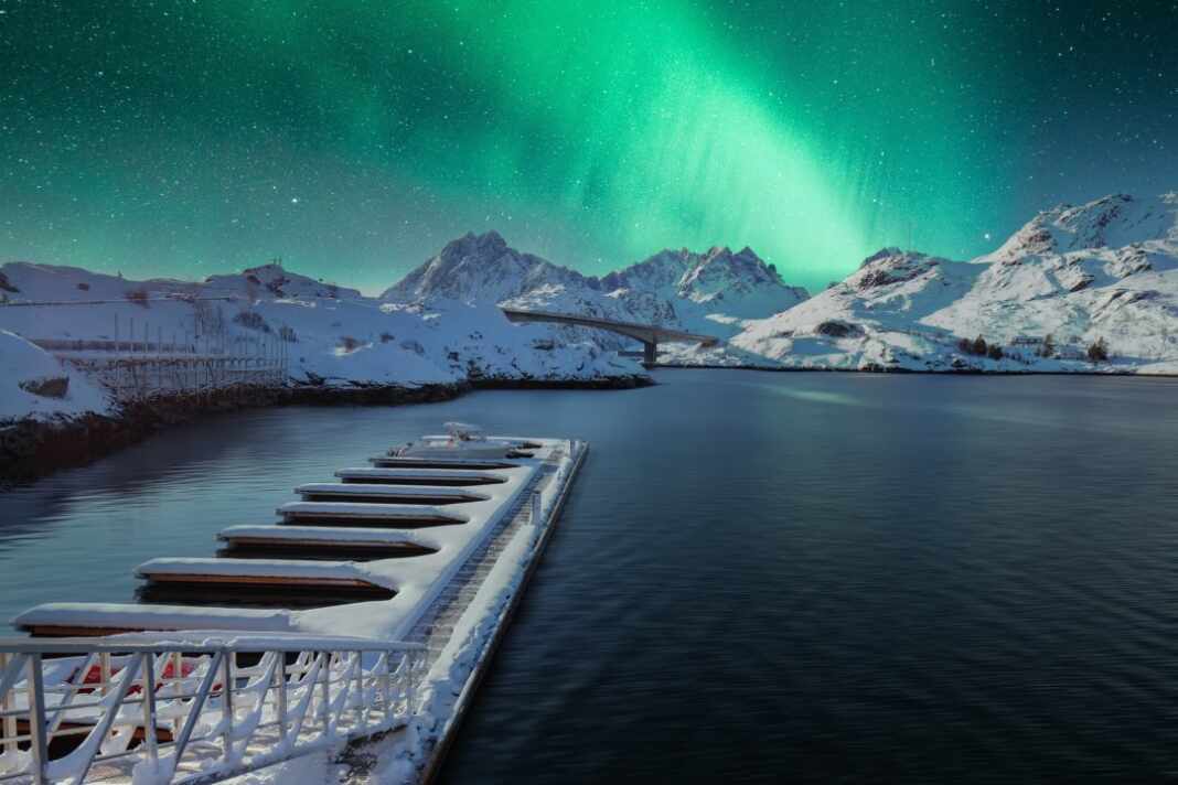 Auroras boreales sobre un muelle en el norte de Noruega, ruta de un crucero en Noruega