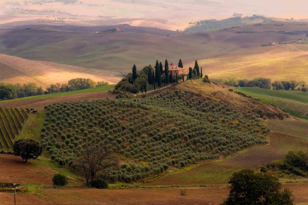 Casa de campo toscana sobre una colina rodeada de cipreses en otoño