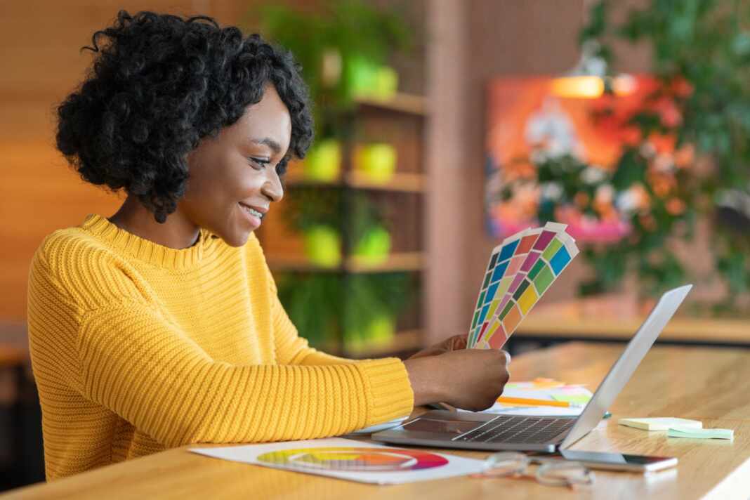 Diseñadora trabaja con una paleta de colores en su computador