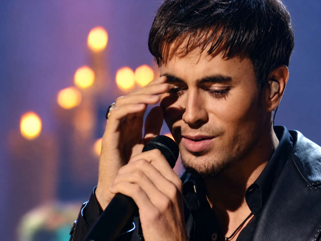 Enrique Iglesias canta Hero con un micrófono en la mano
