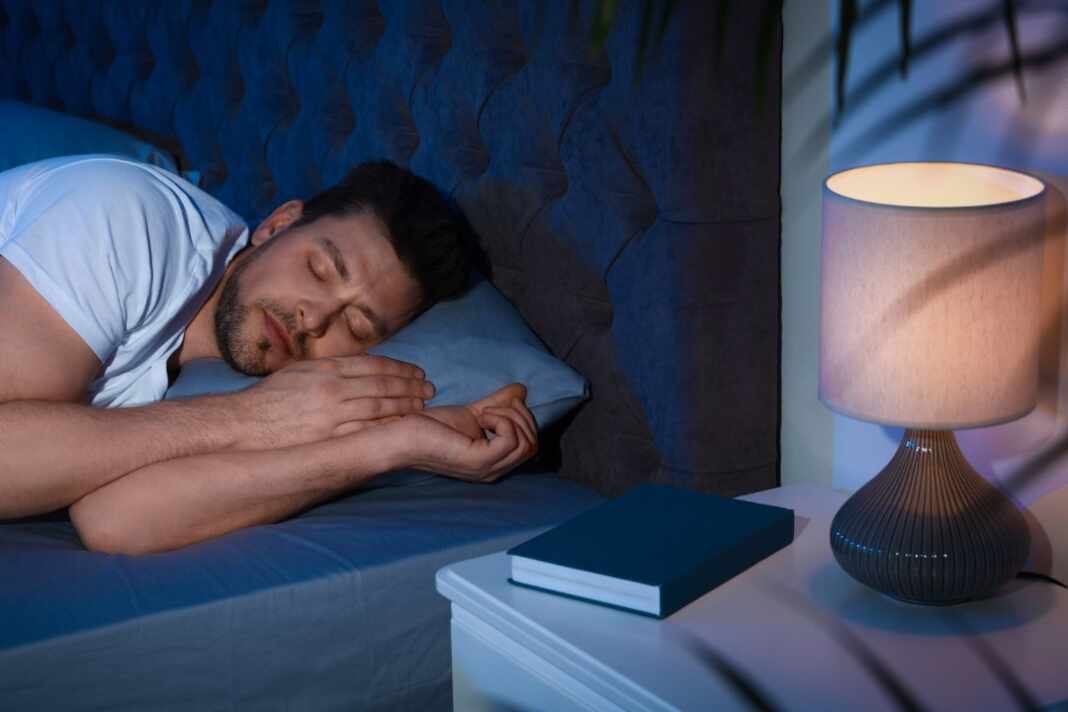 Habitación con luz de noche que entra por la ventana mientras una persona duerme