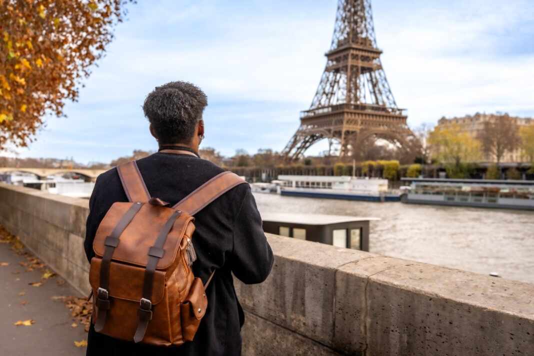 Jóvenes caminan junto al río Sena en París, destino para trabajar en Francia con la visa vacaciones-trabajo