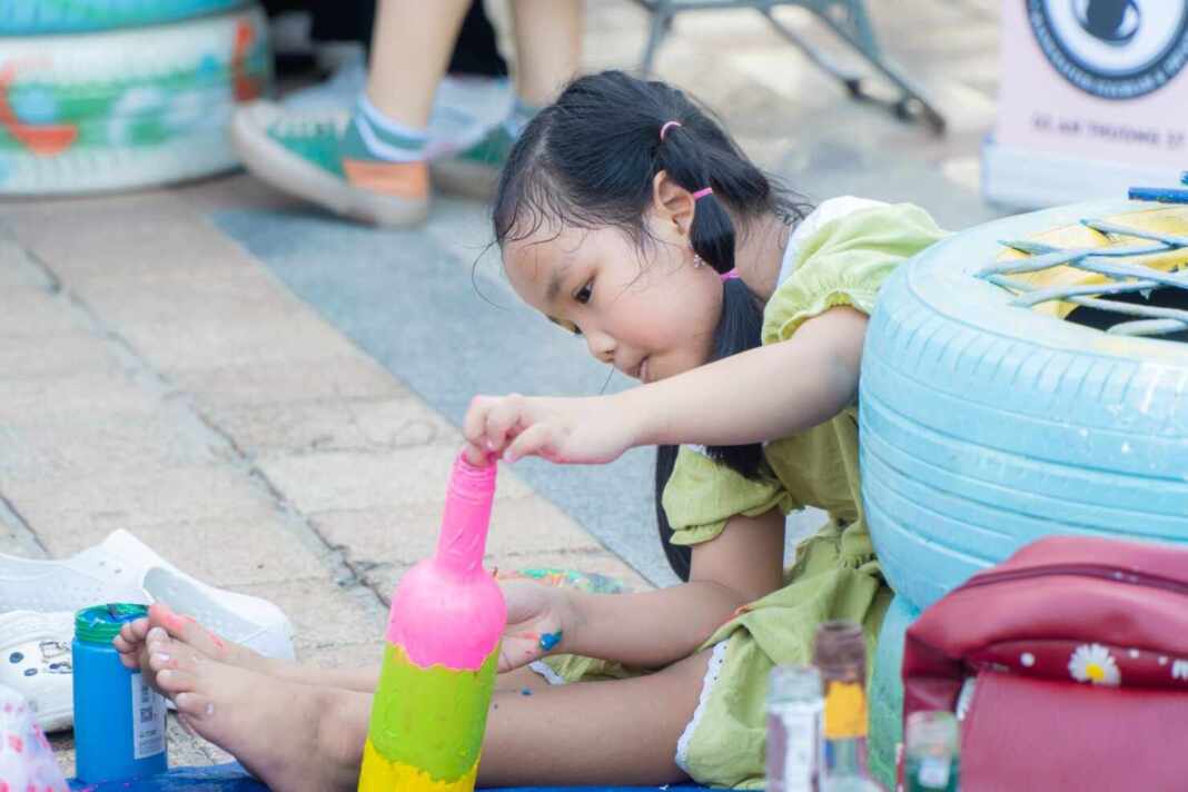 Niña haciendo una manualidad con una botella de plástico, ventilador casero sin electricidad